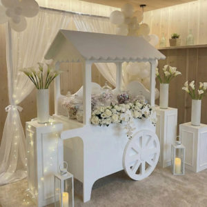 Carrettino confettata total white dal design elegante e scenografico, ideale per allestimenti raffinati e ambientazioni di classe. Perfetto per white party, matrimoni, eventi privati ed eventi aziendali, questo elemento decorativo valorizza la location creando un punto focale luminoso, moderno e di forte impatto visivo. La struttura minimal e pulita si integra armoniosamente in contesti luxury, shooting fotografici e setup esclusivi, offrendo una soluzione estetica ricercata per confettate, sweet table e corner decorativi. Una scelta distintiva per chi desidera un’atmosfera sofisticata, coerente e altamente fotografabile.